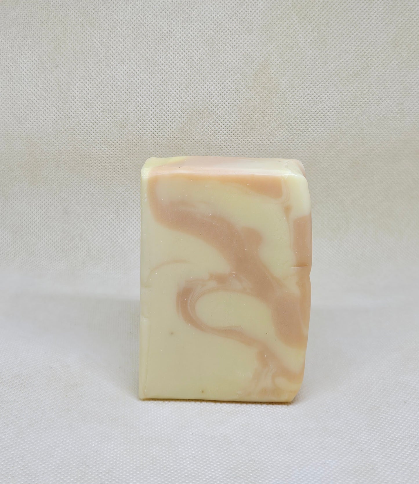 Marbled soap bar on a white fabric background