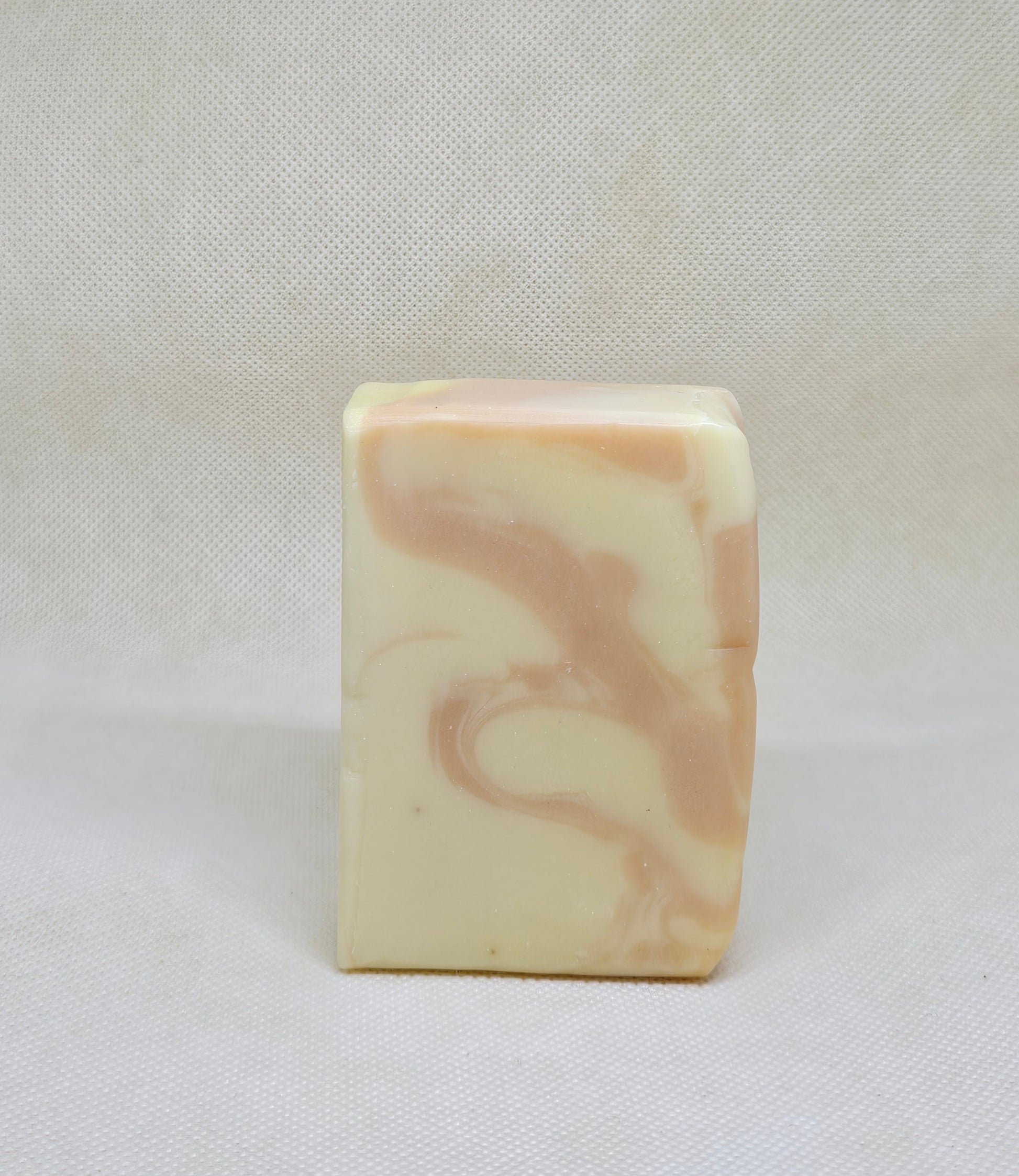 Marbled soap bar on a white fabric background